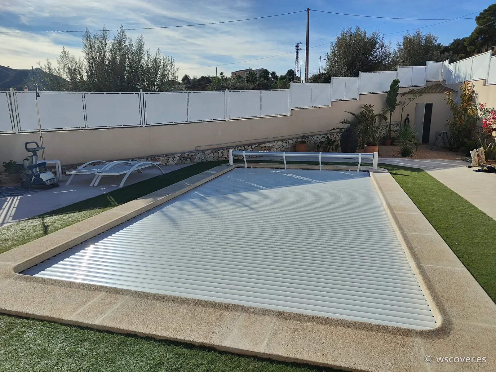 White slatted pool cover beside a terrace, installed by WS Cover