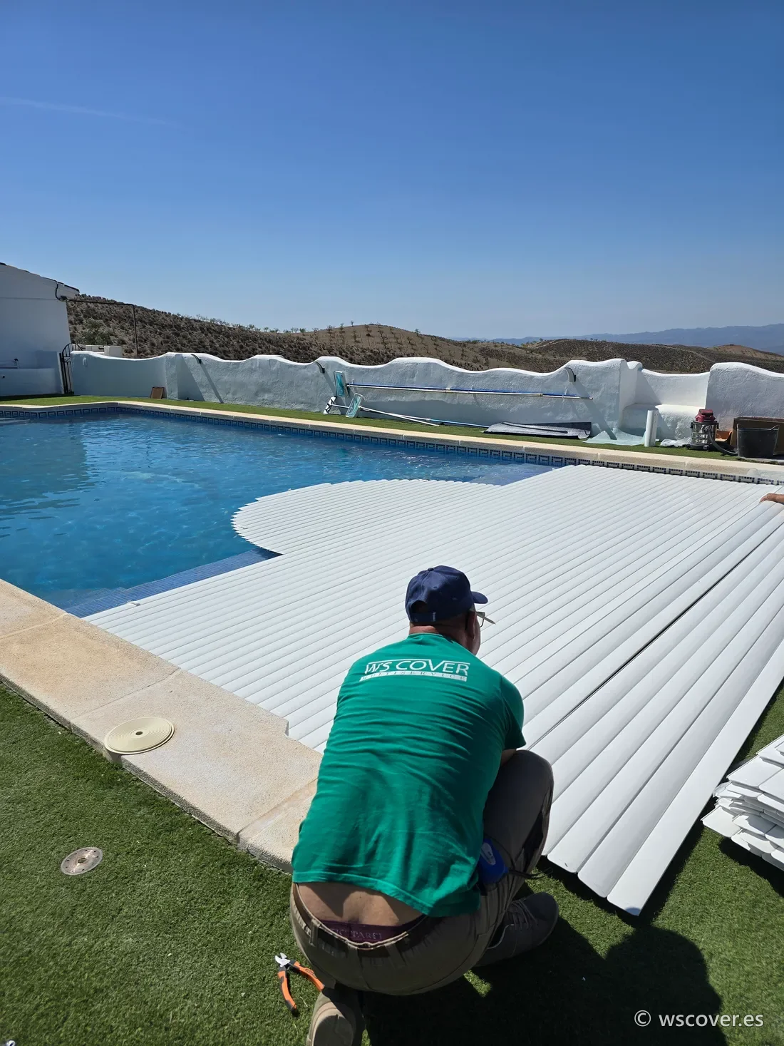 Técnico de WS Cover instalando lamas automáticas sobre piscina