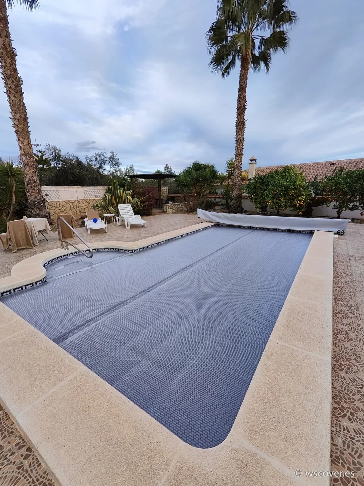 Cubierta de burbuja de 800 micras sobre piscina con escalera romana, entre palmeras