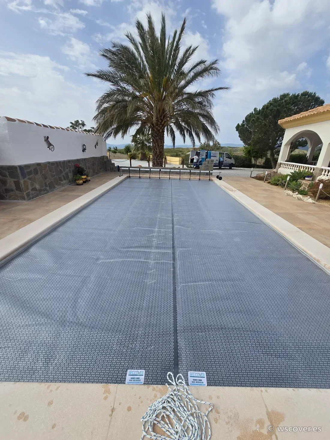 Cubierta GeoBubble EnergyGuard 800 gris instalada sobre piscina en forma de L con enrollador, Almería